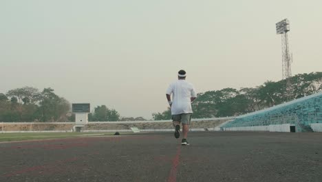 Overweight Man Running At Stadium