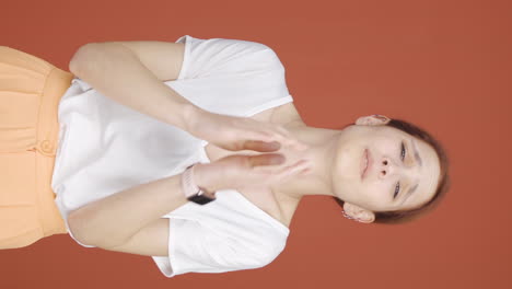 video vertical de la mujer haciendo el pequeño letrero con su mano.