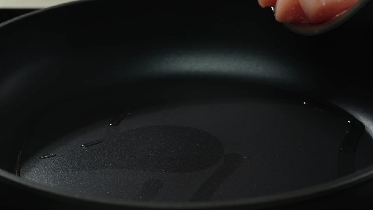 Man slicing raw turkey or chicken meat fillet on oak cutting board closeup, cooking with knife on restaurant kitchen. High quality 4k footage