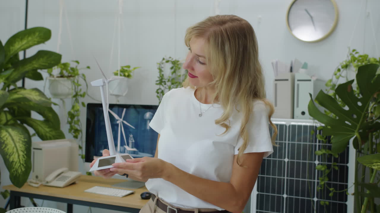 Cheerful Engineer Posing for Camera with Model of Wind Turbine