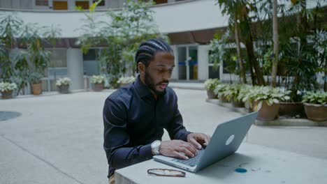 businessman working on laptop in outdoor courtyard