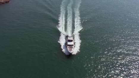 gran yate cruzando el marco rumbo al puerto dejando una hermosa estela atrás, vista aérea inclinada hacia abajo