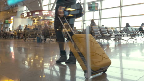 Woman-with-trolley-bag-walking-slowly-in-lounge