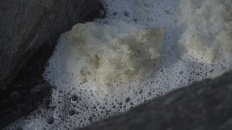 La schiuma del fiume scorre sull'acqua