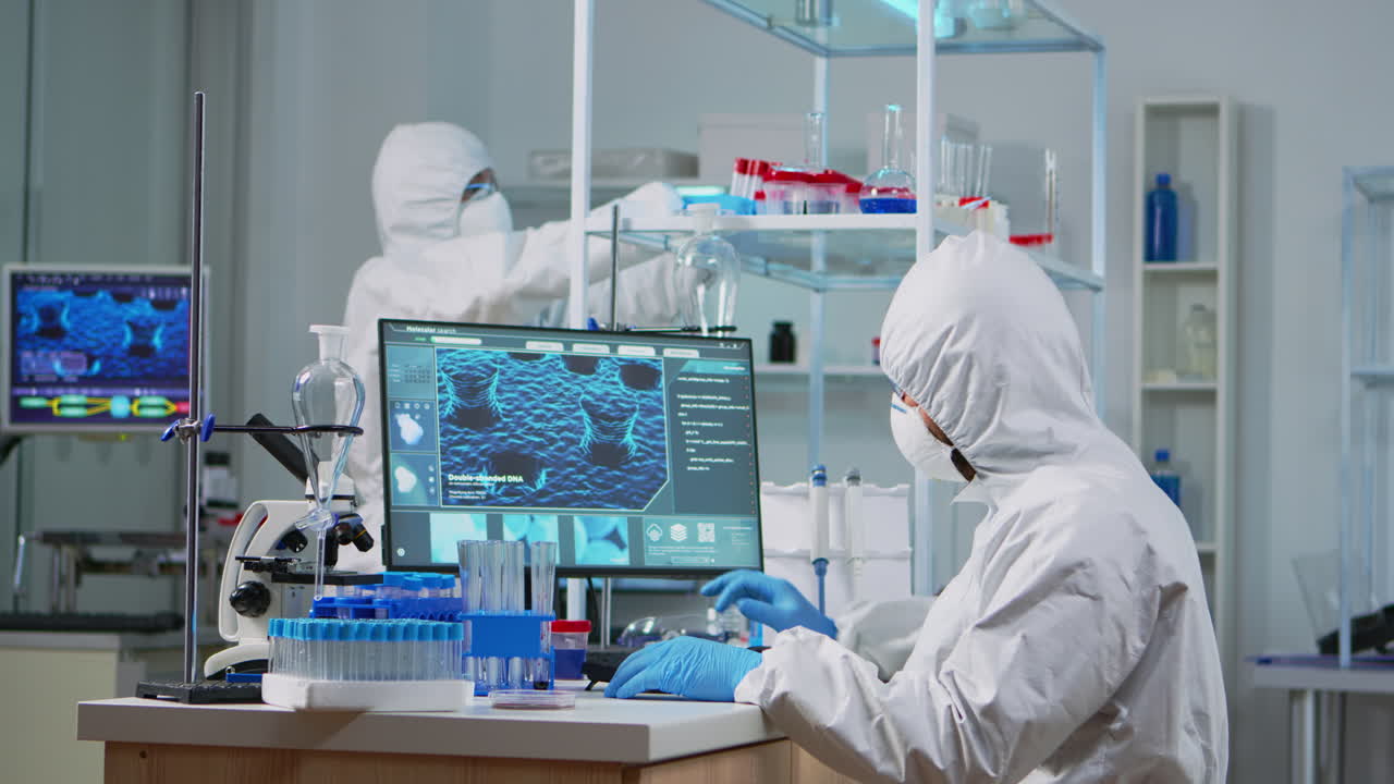 ppe 슈트를 입은 신경학자가 백신 개발에 일하고 있습니다.