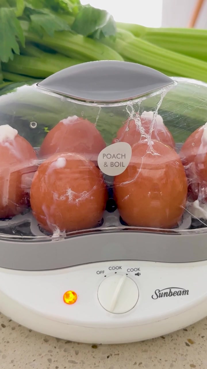 Eggs steaming beside fresh vegetables on counter