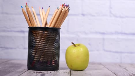 colored pencils and apple