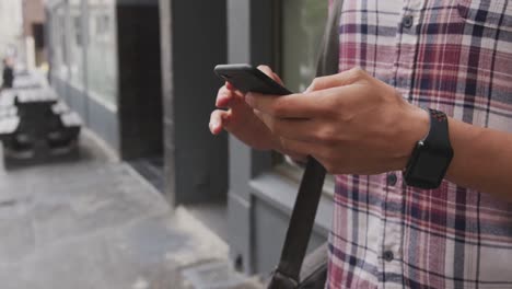 Caucasian-man-using-his-phone-on-street