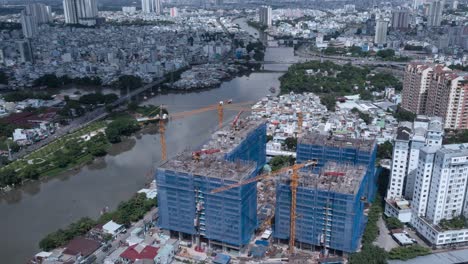 hiperlapso de un gran proyecto de construcción residencial moderno en el sudeste asiático desde una vista aérea a lo largo de un canal con casas originales de poca altura y expansión urbana