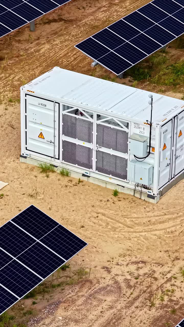 Generator container in the middle of a solar panel field. Vertical aerial