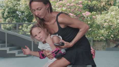 mujer tomando una selfie con su hija en el skatepark