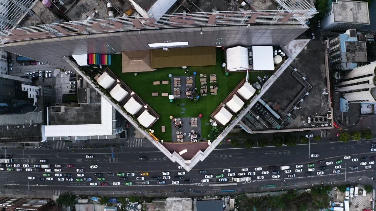 Um drone sobrevoa a torre de Chengdu, revelando o trânsito intenso, os quarteirões da cidade e os arranha-céus. Transição perfeita para vídeos imobiliários, de arquitetura, transporte e corporativos que mostram a escala da megacidade.