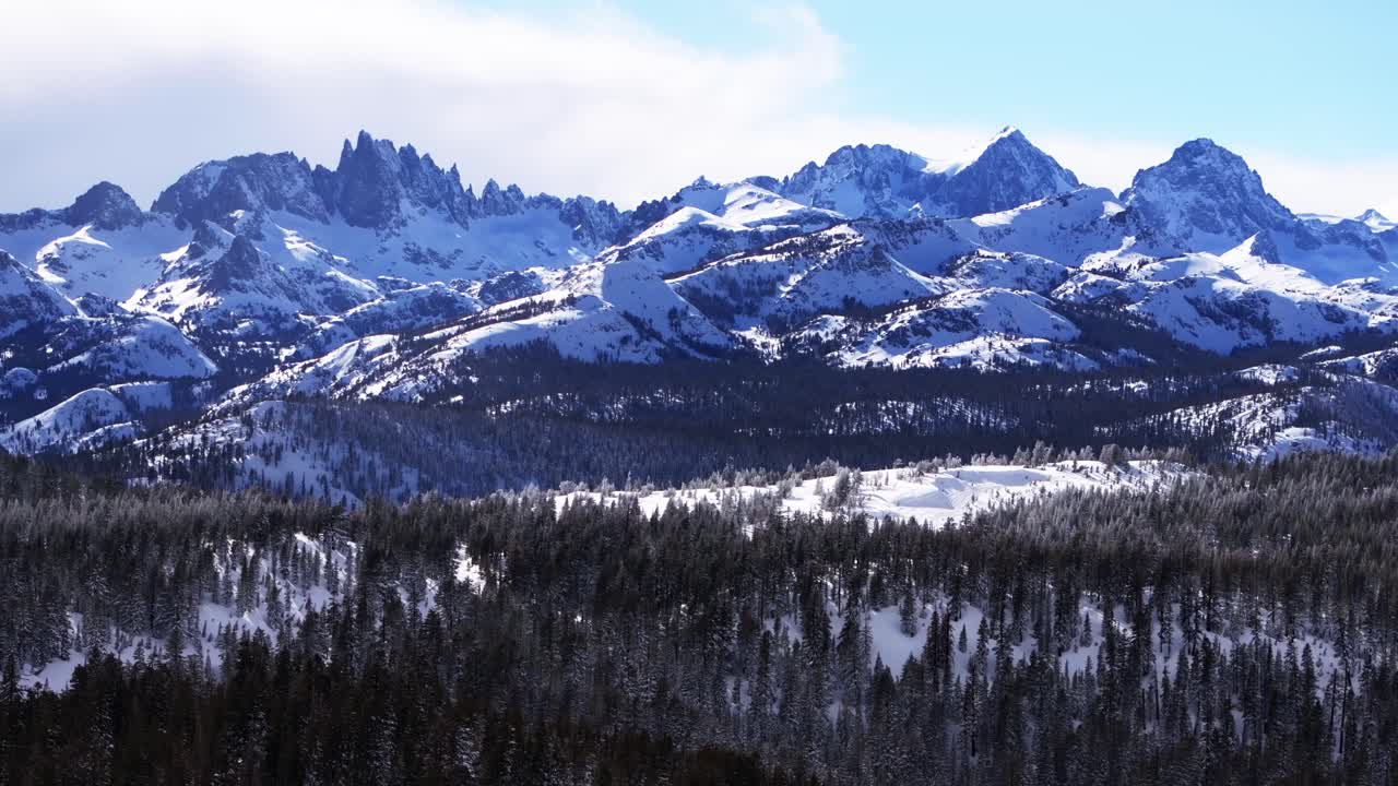 Minarets, zerklüftete, aufragende Gipfel, Gipfelblick, Panoramalandschaft, Luftaufnahme mit Drohne, Winter, Skigebiet Mammoth Mountain, Kalifornien, Inyo National Forest, die Hemlocks, sonniger blauer Himmel, bewölkte Aufwärtsbewegung.