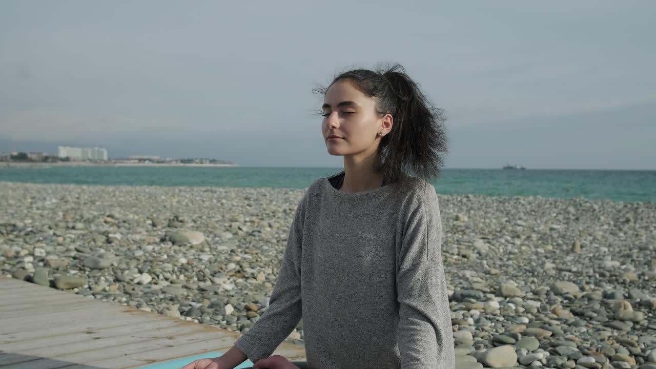 Kvinde mediterer på stranden