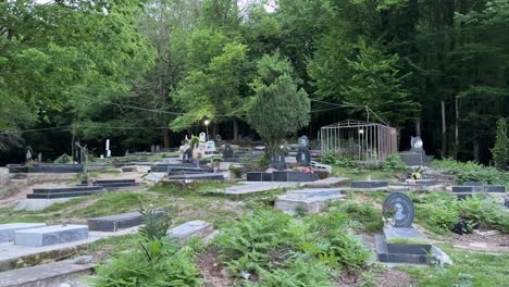 a cemetery in the dark forest green area in the northern middle east asia head stone for burial funeral in scary place in mountain rural village in gilan cinematic scenic view wonderful location