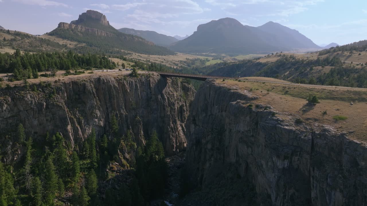 Aerial panoramic orbit of Sunlight Creek Bridge in Wyoming, showcasing the dramatic canyon and surrounding mountain landscape