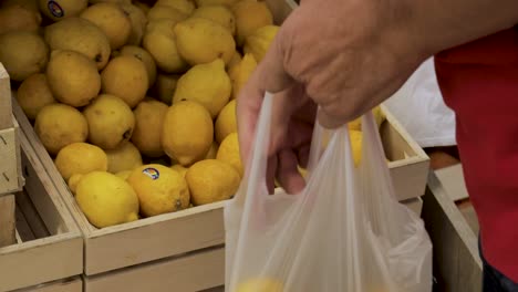 man picking lemons in marketplace