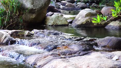 Agua-Cristalina-Y-Reluciente-Que-Fluye-En-Un-Lecho-Rocoso-áspero-De-Cerca