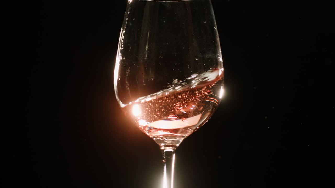 Rose Orange or white wine bottle and glass against a sunset in a peaceful vineyard, pouring of ecological natural wine.
