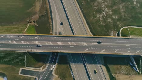 Vista-Aérea-De-Drones-De-Arriba-Hacia-Abajo-De-La-Carretera-De-Varios-Niveles-Con-Autos-En-Movimiento-Al-Atardecer