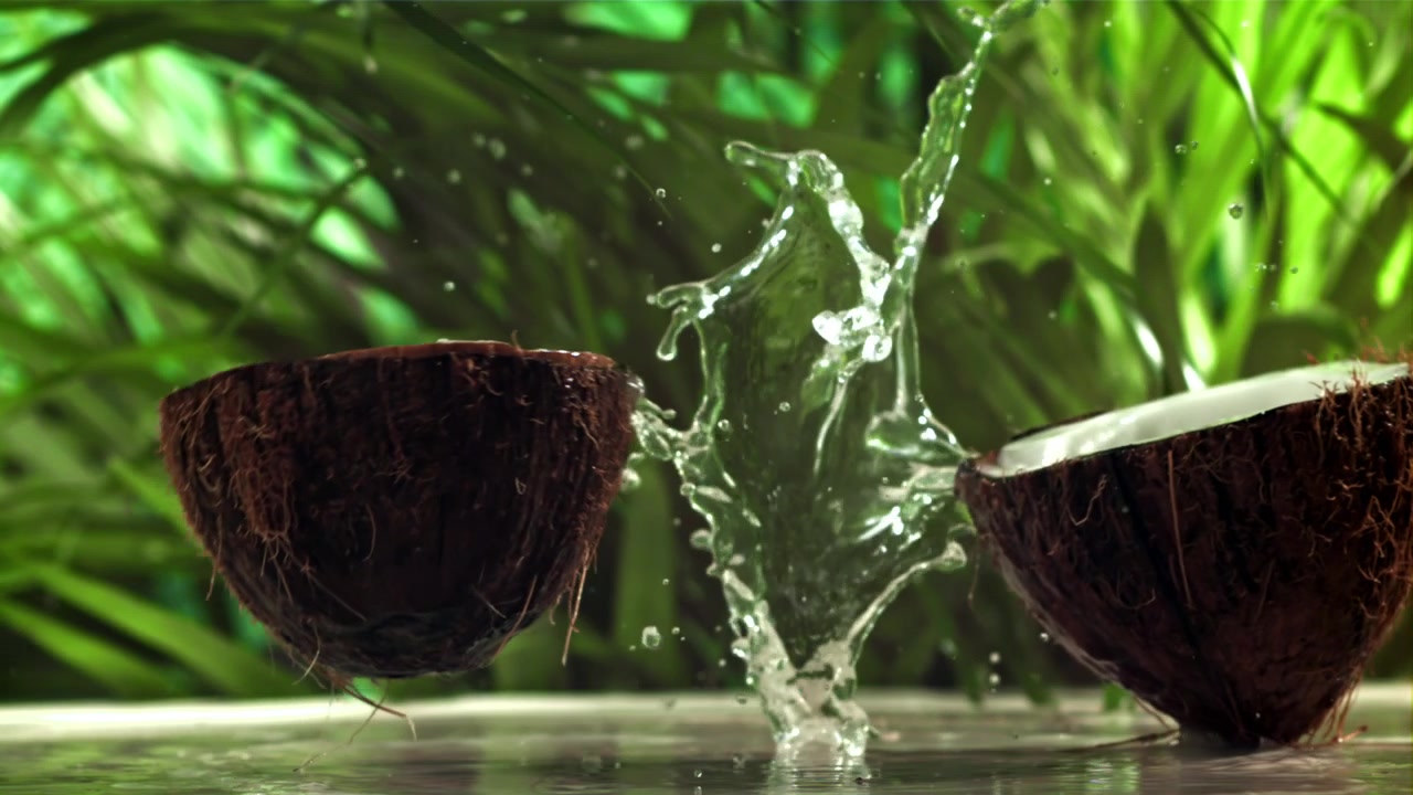 Slow Motion Coconut Breaking and Splashing Water with Green Background