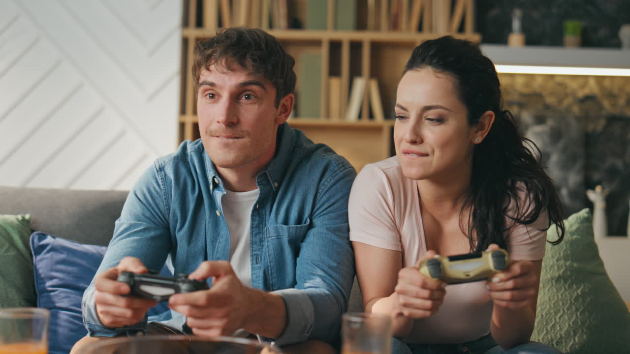 jugadores felices jugando videojuegos usando controladores sentados en el sofá de cerca..