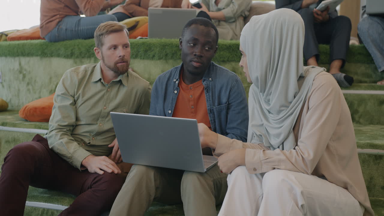 Diverse Group Discussing Project on Laptop