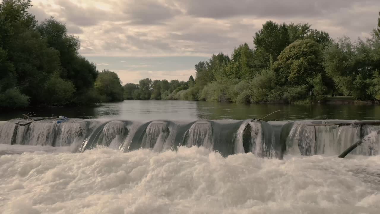 Aerial drone shot flying over waterfall panning up to reveal Boise River