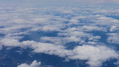 view from aircraft of lower cloud deck near built up area