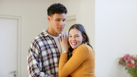 Portrait-of-happy-diverse-couple-embracing-at-home,-in-slow-motion