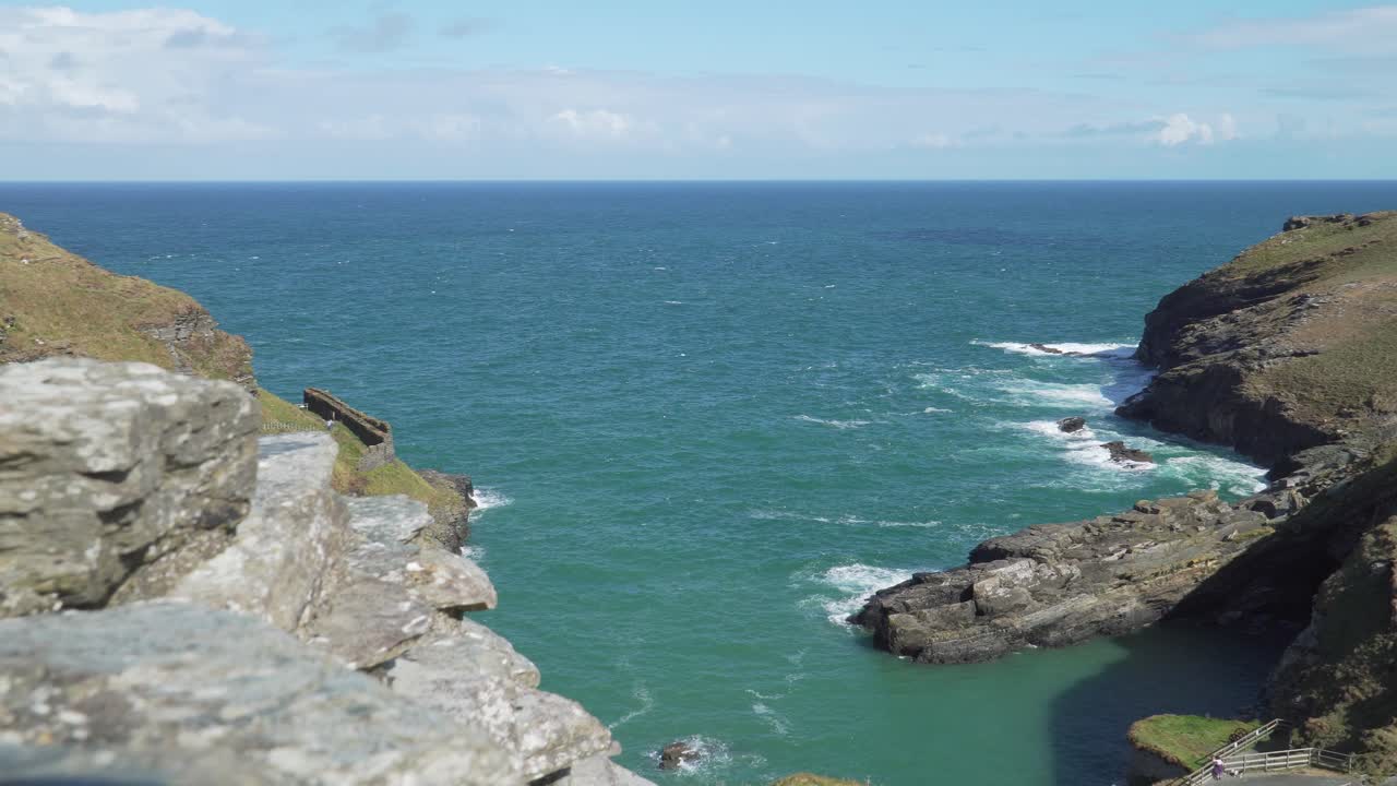 Tintagel, Cornwall Birleşik Krallık'ta bir sahil. Tintagel kıyılarına vuran dalgalar. Arka planda mavi deniz ve mavi gökyüzü