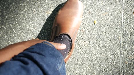 person wearing brown shoes and black socks with spots