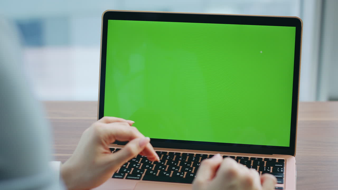 una mujer irreconocible hablando en video por una computadora portátil de pantalla verde de cerca.