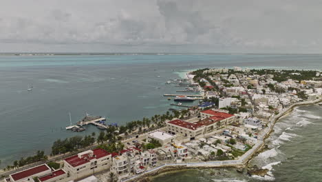 Isla-Mujeres-Mexiko-Luftaufnahme-V13-Überflug-Des-Mexikanischen-Marineministers-In-Der-Quinta-Region-In-Richtung-Des-örtlichen-Stadtzentrums,-Aufnahme-Von-Inselansichten-Mit-Am-Pier-Angedockter-Fähre-–-Aufgenommen-Mit-Mavic-3-Cine-–-Juli-2022