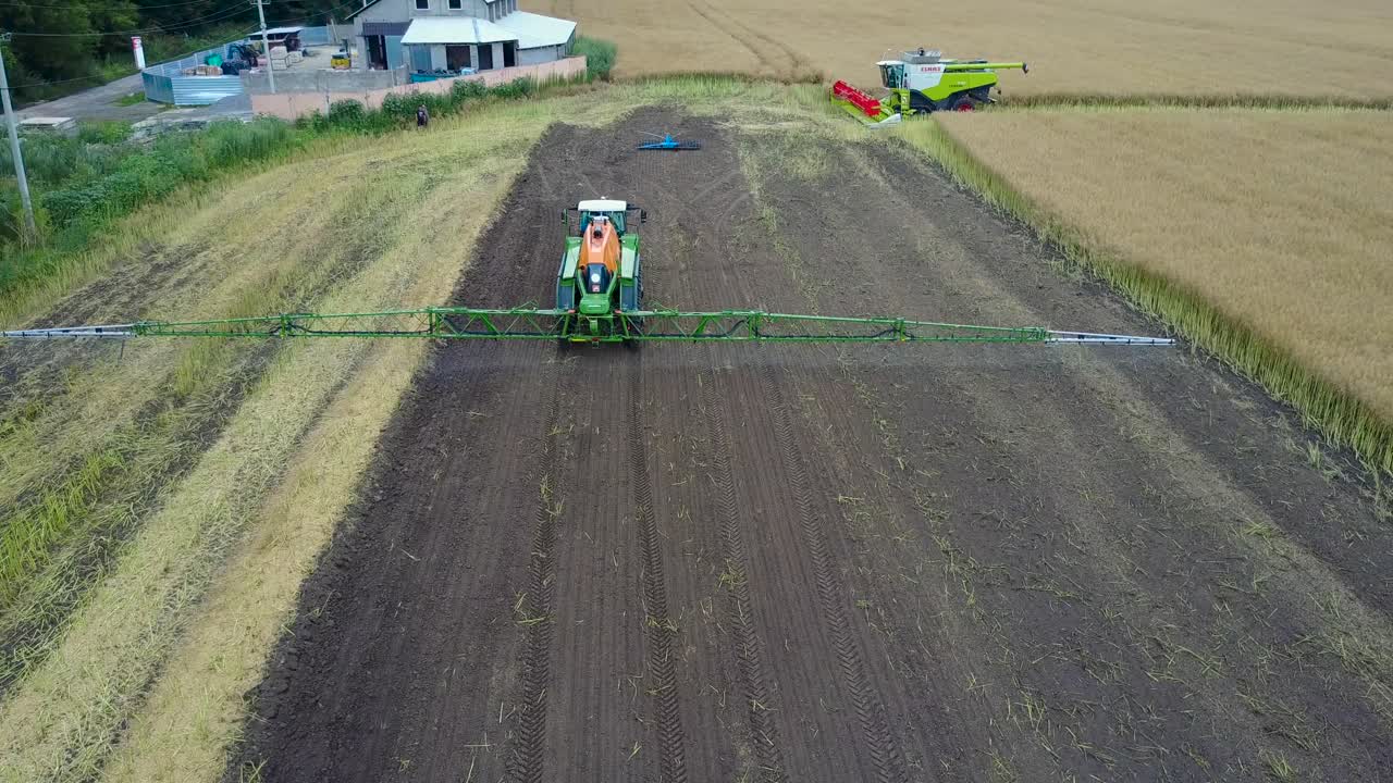 Tractor Spraying Agricultural Field. VINNITSA, UKRAINE - JULY 2017: Aerial shot of the moderm tractor spraying agricultural field