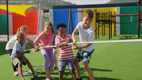 Front-view-of-mixed-race-schoolkids-playing-tug-of-war-in-the-school-playground-4k