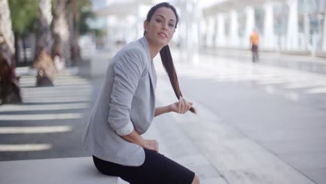 una mujer bonita sentada al lado de una pasarela peatonal