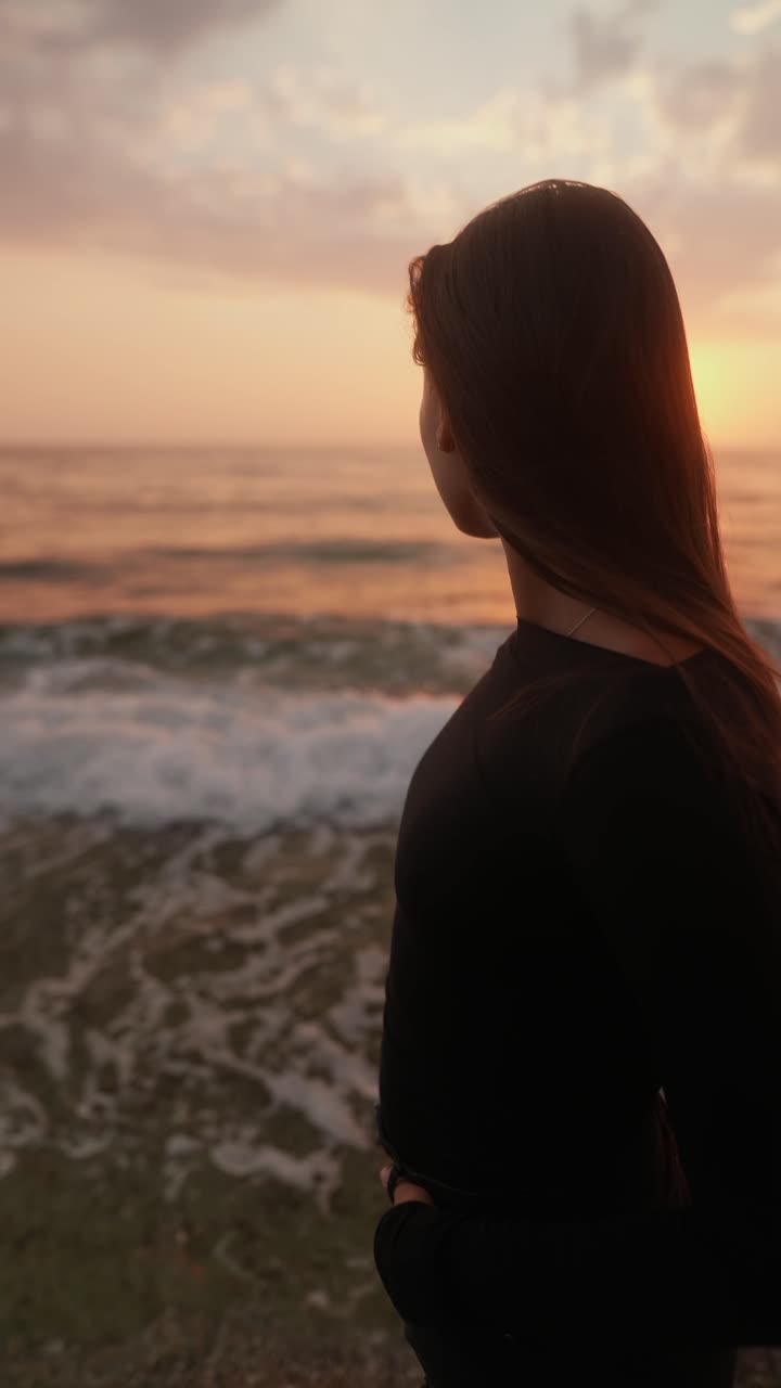 mujer viendo el amanecer en la playa