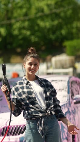 young woman washing car at car wash