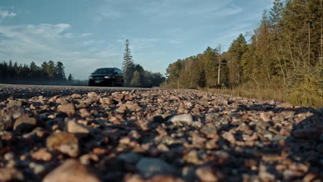 ground level shot of minivan driving down rural ontario highway toward camera on gravel shoulder