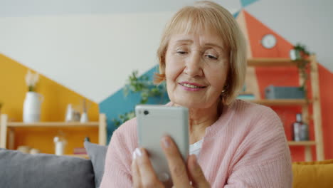 mujer mayor usando un teléfono inteligente en casa