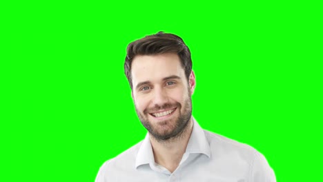 hombre sonriente de pie contra la pantalla verde