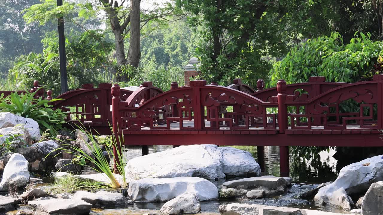 un puente de jardín pacífico sobre un arroyo de agua tranquila