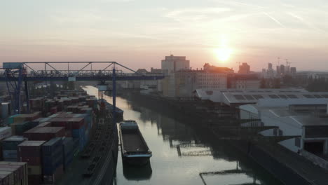 Port-Warehouses-and-Cargo-loading-cranes-in-beautiful-morning-Sunlight,-Aerial-forward-crane-up-slow