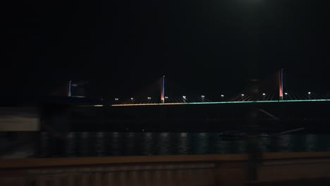 passing by an illuminated cable-stayed bridge at night