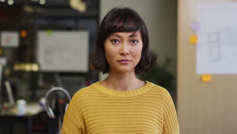 Portrait-of-happy-biracial-businesswoman-looking-at-camera-at-office