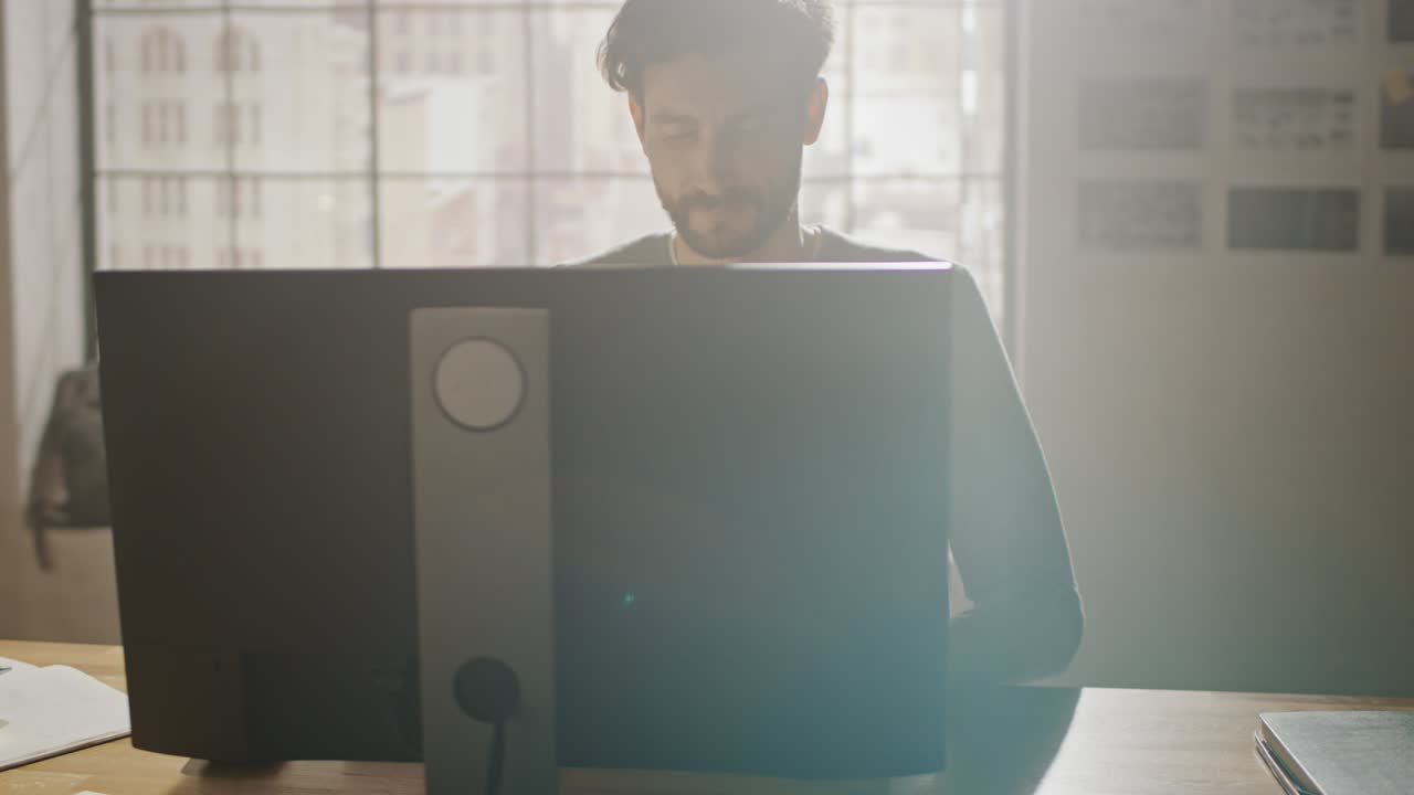 크리에이티브 디자이너는 사무실 스튜디오에서 책상에 앉아 스마트폰 소프트웨어 개발 애플리케이션을 화면에 고 있는 데스크 컴퓨터에서 작업하고 있습니다.