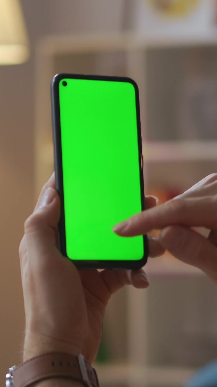 Primo piano di una mano che scorre su uno smartphone con schermo verde