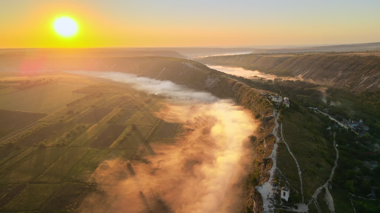 Aerial drone view of the Old Orhei at sunset. Valley with river and fog, village, monastery located on a hill in Moldova