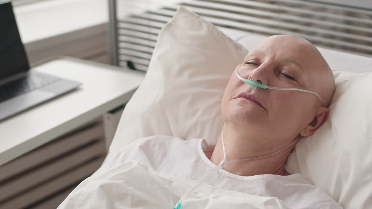 Bald Female with Nasal Cannula Sleeping in Bed